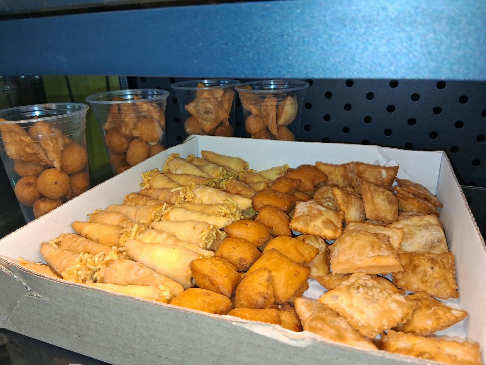 Caixa com variedade de salgados fritos para encomenda
