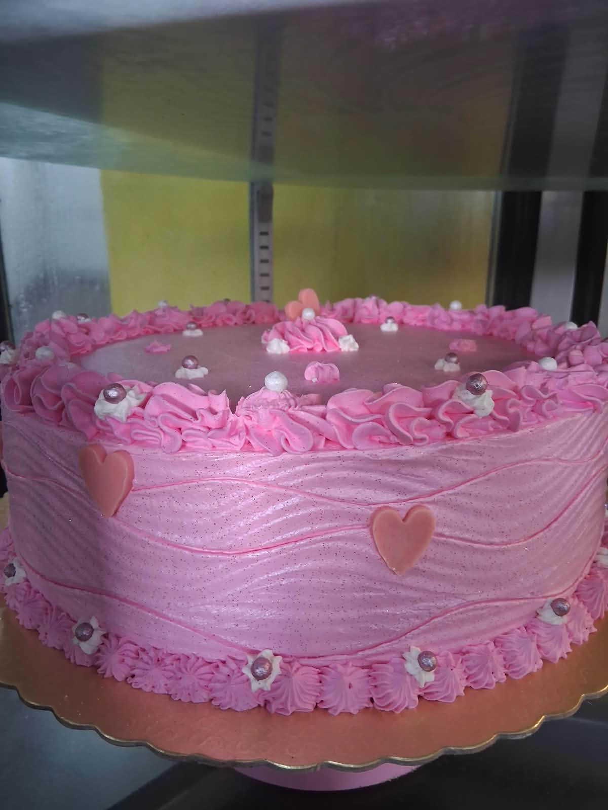 Bolo rosa decorado com corações e pérolas