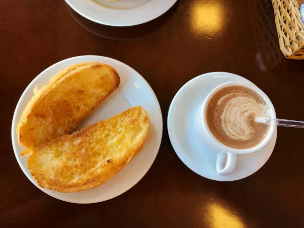 Café com leite e pão na chapa servidos no café da manhã da Pão & Cia Gourmet